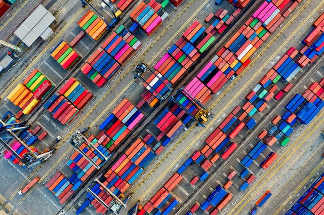 Aerial view of a busy container port with stacked shipping containers